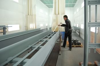 Tom demonstrates glide installation in the company's paint booth.